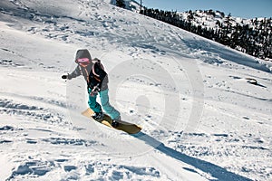 Woman freeriding from mountain on a professional snowboard