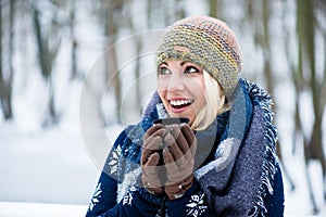 Woman freezing on a cold winter day warming herself up with hot drink