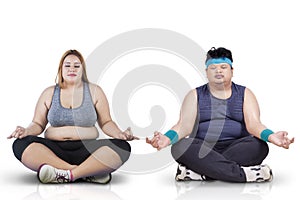 Woman and friend doing yoga on studio