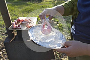 A woman fries fish on a wood-burning stove