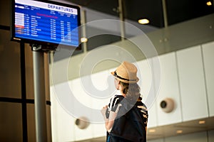 Woman in front of airport flight information panel