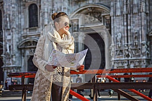 Woman in front of Duomo in Milan with map looking into distance