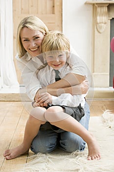 Woman in front hallway hugging young boy and smili