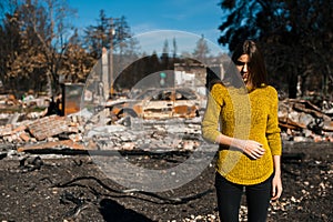 Woman in front of her burned home after fire disaster