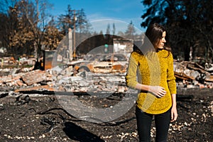 Woman in front of her burned home after fire disaster