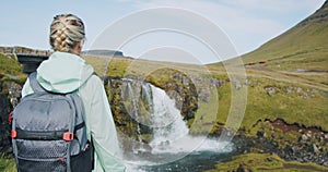 Woman in front of Kirkjufellsfoss watterfall and Kirkjufell in northern Iceland