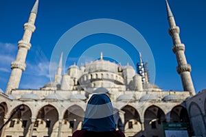 Woman in front of the Sultan Ahmed Mosque in Istanbul, Turkey.