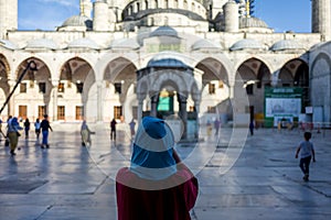 Woman in front of the Sultan Ahmed Mosque in Istanbul, Turkey.