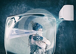 Woman frozen in an ice cube under the air jet of an air conditioner