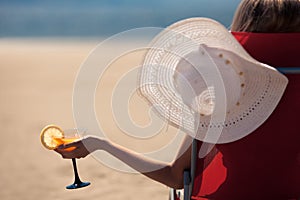 Woman with a fruit cocktail on a tropical beach