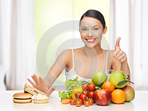 Woman with fruits rejecting junk food