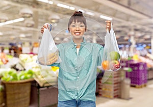 woman with fruits in reusable and plastic bags