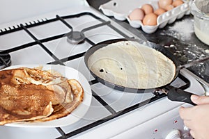 Woman fry pancakes at the traditional Russian holiday  Carnival Maslenitsa Shrovetide