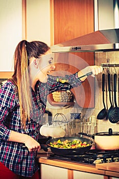 Woman frying frozen vegetables. Stir fry.