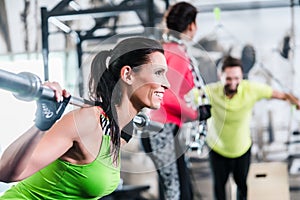 Woman in functional training lifting weights in gym photo