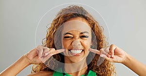 Woman, funny face and studio with goofy comedy on grey background or humor mockup space, silly or joking. Female person