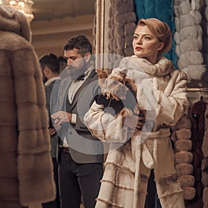 Woman in fur coat with man, shopping, seller and customer.