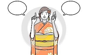 Woman in furisode pointing while on the phone photo