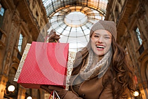 Woman in Galleria Vittorio Emanuele II showing shopping bags