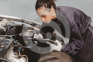 Woman garage worker maintenance checklist at automobile service center, Female in auto mechanic car technician work service check