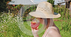 Woman in garden drinking cocktail