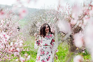 a woman in the garden of flowering peach trees in the spring