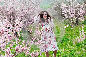 a woman in the garden of flowering peach trees in the spring