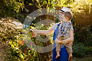 Woman gardener with son watering garden