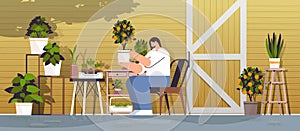 woman gardener taking care of potted orange plant at backyard greenhouse or home garden horizontal