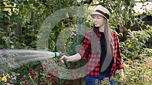 Woman gardener watering garden