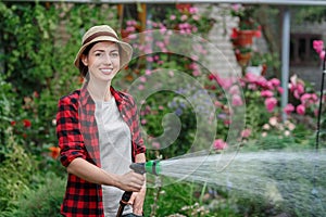Woman gardener watering garden