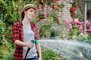 Woman gardener watering garden