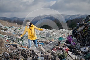 Woman with gas mask walking on landfill, environmental concept.