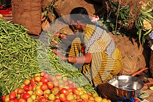 Woman gathering green beans Indian street market