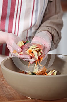 Woman gathering vegetable peelings photo