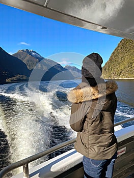 A woman gazes at the breathtaking Doubtful Sound scenery from a cruise in South Island