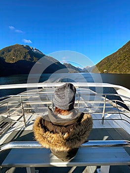 A woman gazes at Doubtful Sound from a cruise in South Island, New Zealand