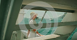 A woman gazes out at the sea from a boat, with the Italian coast in the distance. Tourist in summer journey.