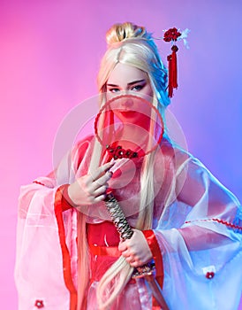 A woman in a geisha costume with a katana and a fan