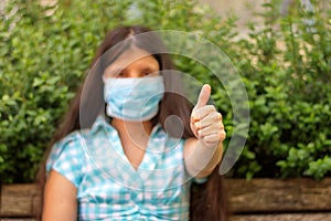 Woman gesturing with hand wearing medicine mask