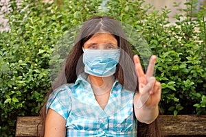 Woman gesturing with hand wearing medicine mask