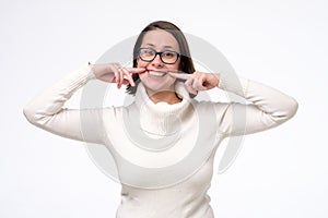 Woman gesturing her beaming white healthy teeth with two forefingers photo