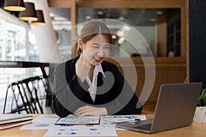 Woman gesturing and looks at laptop screen, businesswoman checking company monthly sales and pretending to be happy as sales meet