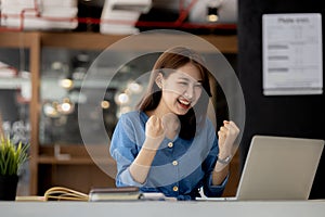 Woman gesturing and looks at laptop screen, businesswoman checking company monthly sales and pretending to be happy as sales meet