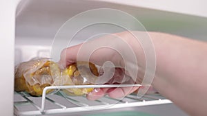 A woman Gets corn from a freezer in a vacuum. Frozen vegetables and fruits, mushrooms, mixtures, soup preparations. Semi