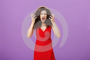 Woman getting annoyed and pissed employees spoiling her perfomance. Portrait of outraged furious female musician in red