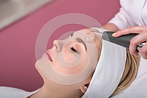 Woman getting cleansing rejuvenating facial treatment in a beauty SPA salon photo