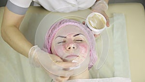 Woman getting a cosmetic medicine treatment, cleaning face skin with mask
