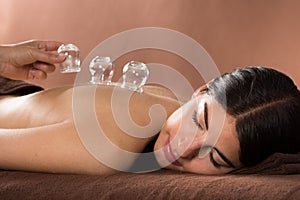 Woman getting cupping treatment at spa