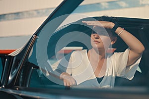 Woman getting down from car searching with eyes for somebody